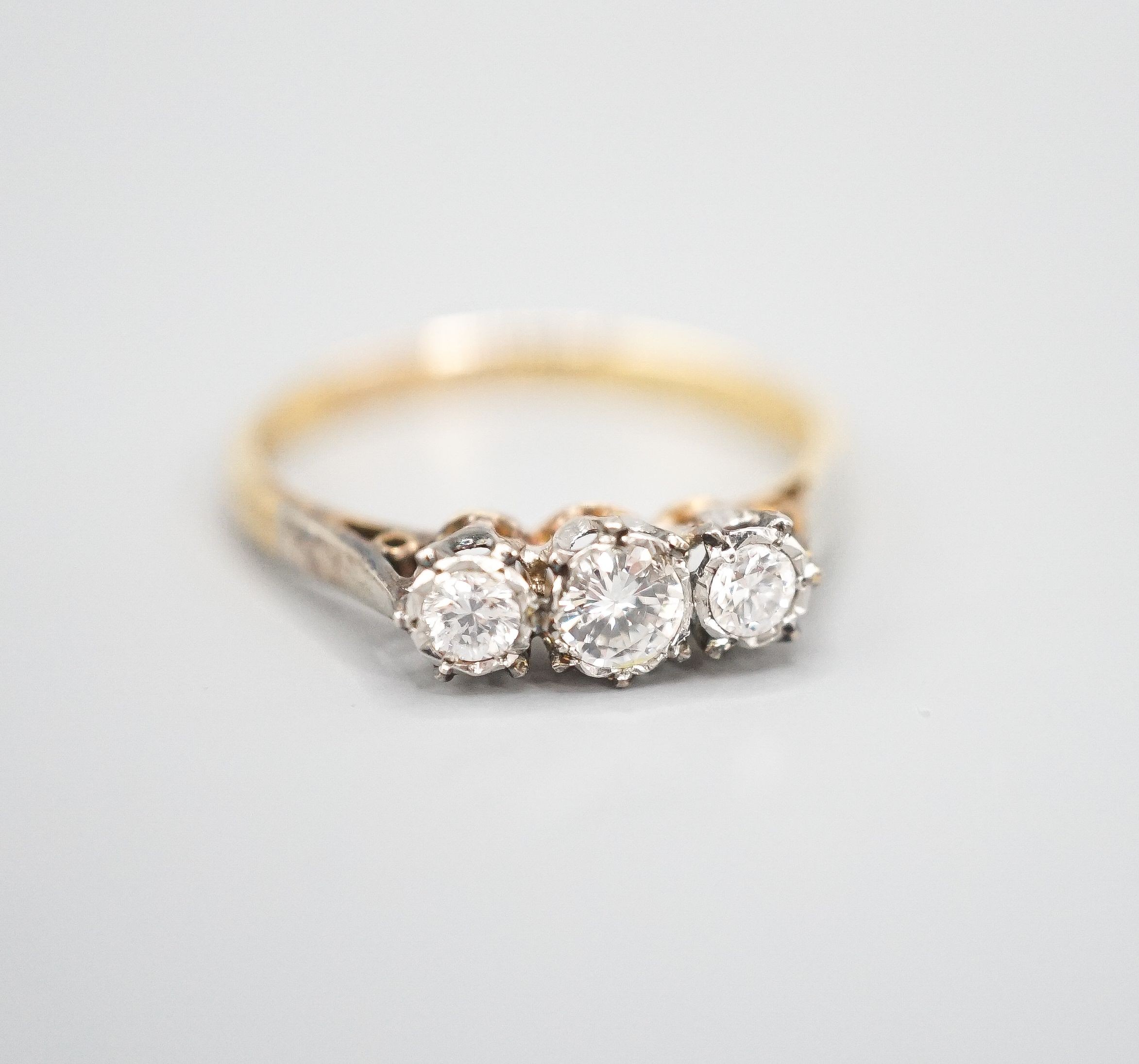 A modern 18ct gold and three stone diamond ring, size Q/R, gross weight 3 grams.